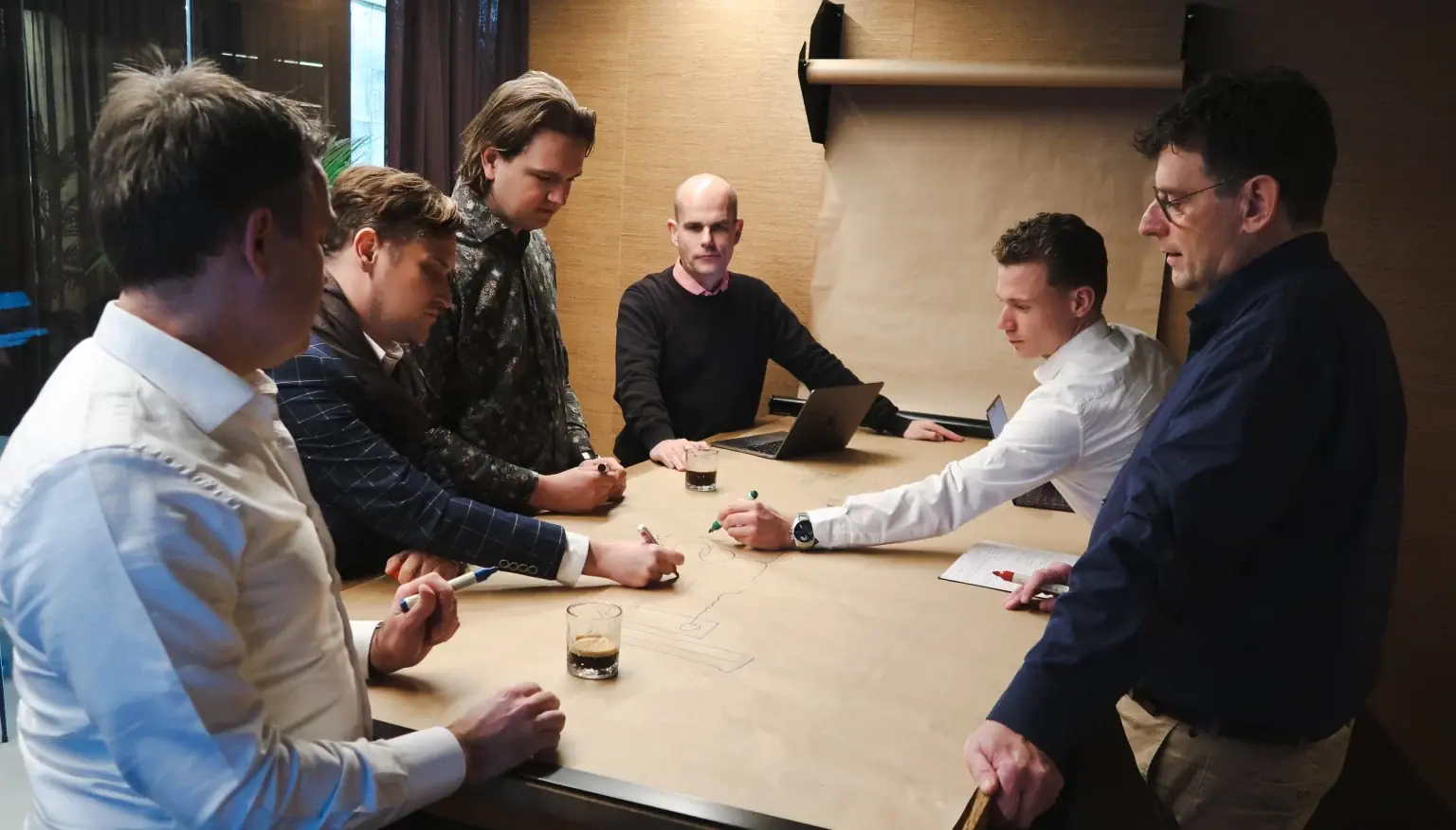 Consultants van Green Fellows werken rond een tafel aan een energie-infrastructuurvraagstuk